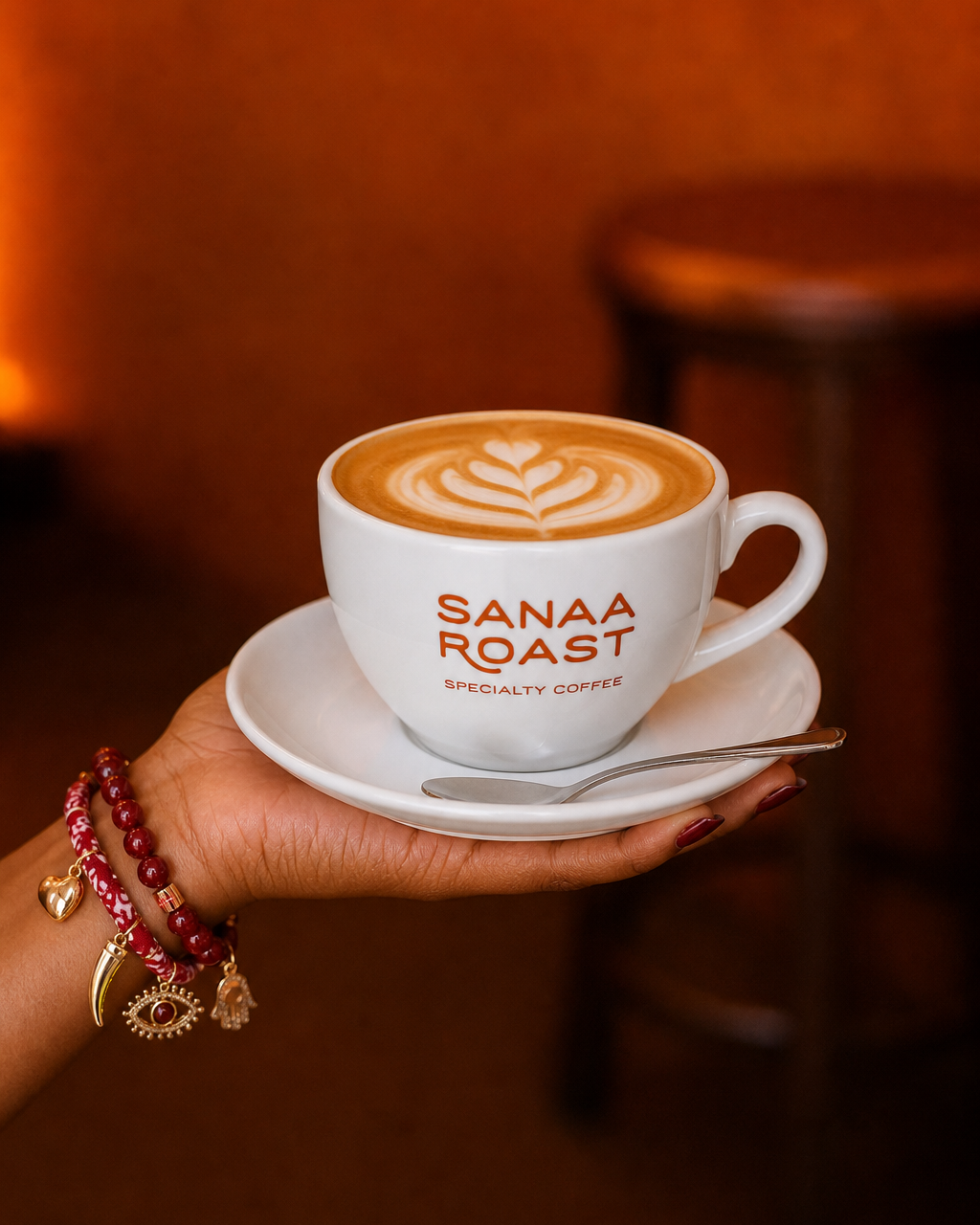 A hand holding a Sanaa Roast latte